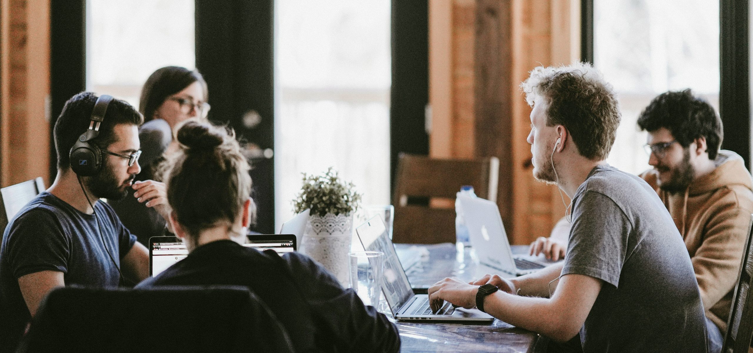 Personnes réunies autour d’une table en discussion dans un espace de travail collaboratif, illustrant la circulation des idées et le dialogue culturel