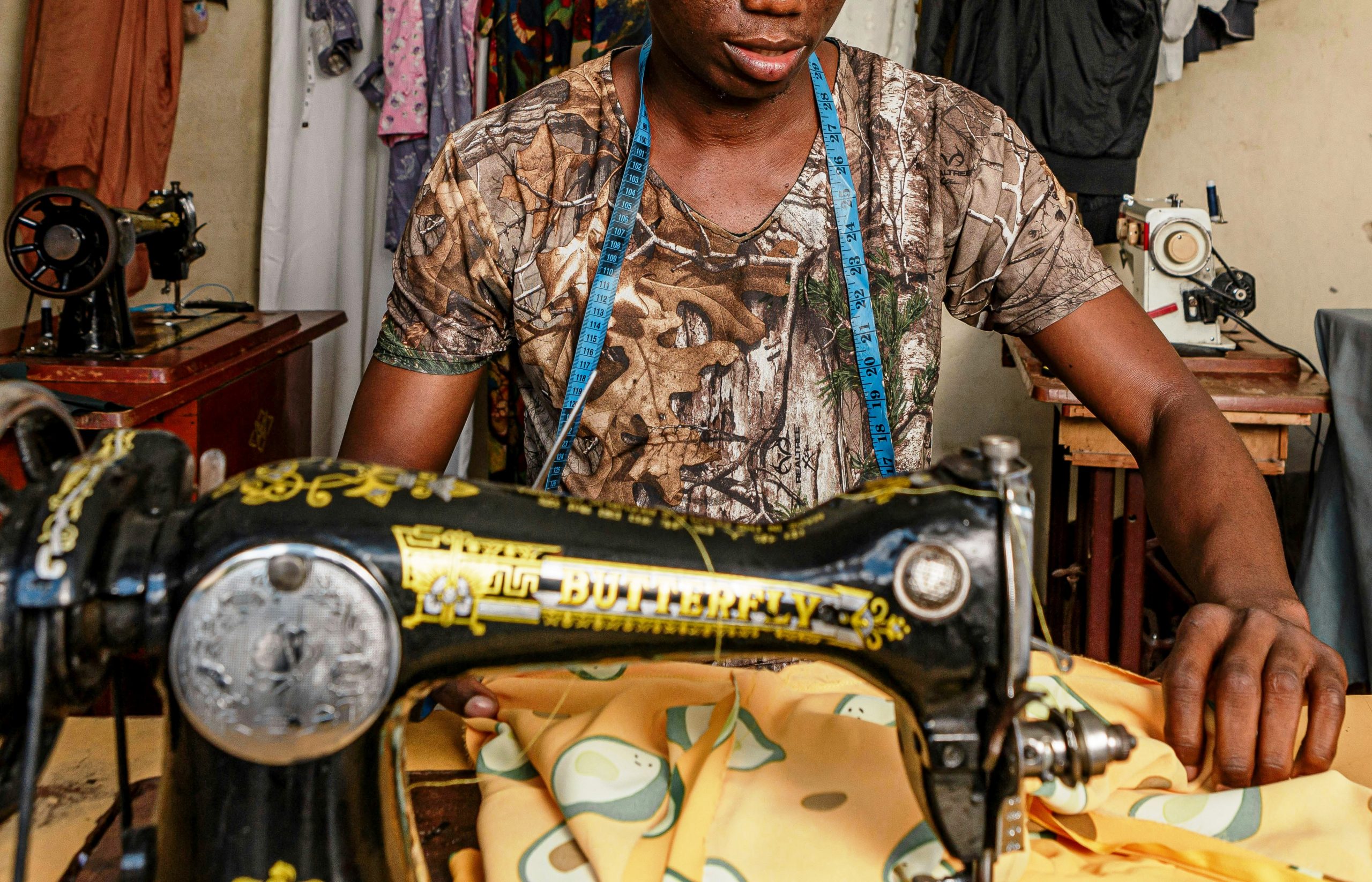 Artisan africain confectionnant un vêtement en pagne dans un atelier de couture