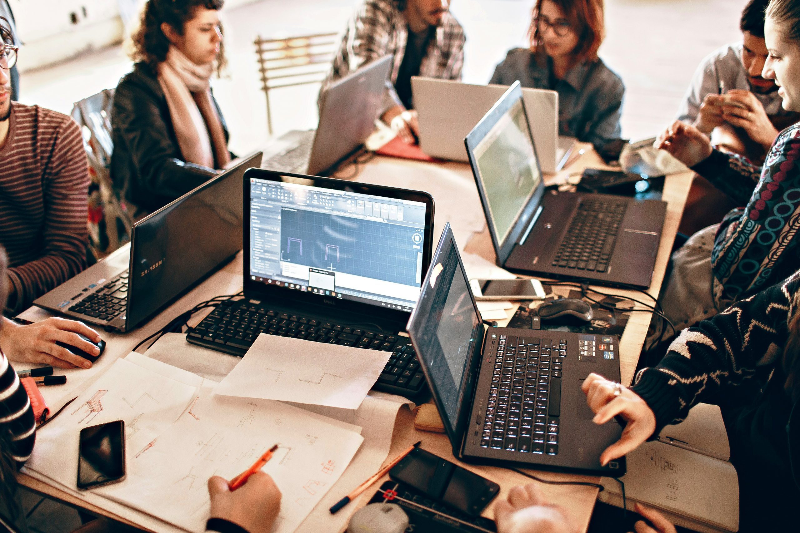 Personnes réunies autour d'une table de travail collaboratif illustrant la construction et l'évolution d'un projet culturel